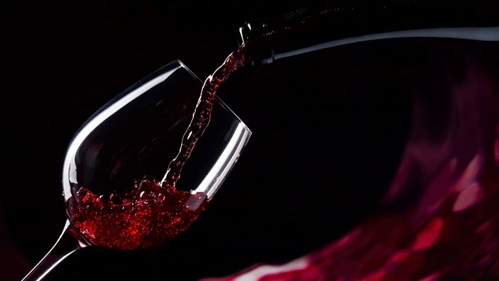 Red wine being poured from a bottle into a glass