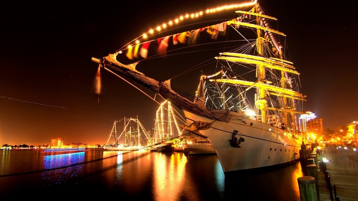 Tall ships decorated with lights at night
