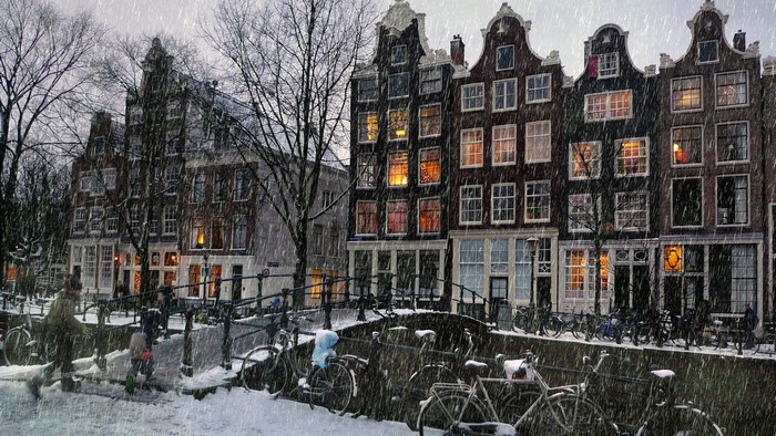 Snowy Amsterdam canal with bicycles
