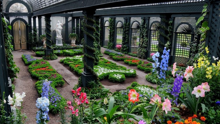 Greenhouse garden with ornate doors and statues