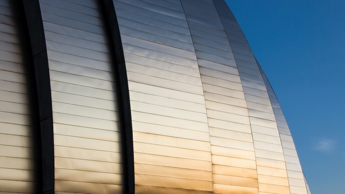 Curved Metal Building Facade Against Blue Sky