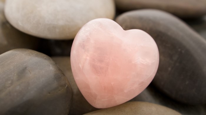Pink heart stone on pebbles
