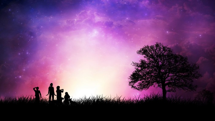 Silhouettes of people and a tree against a colorful sky