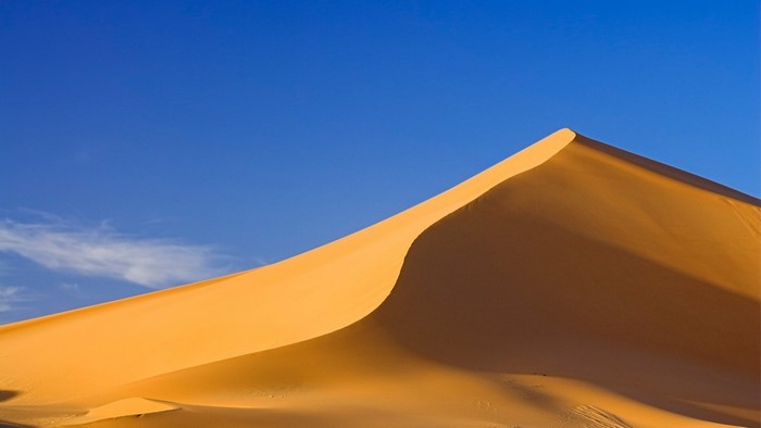 Sand dune against a blue sky