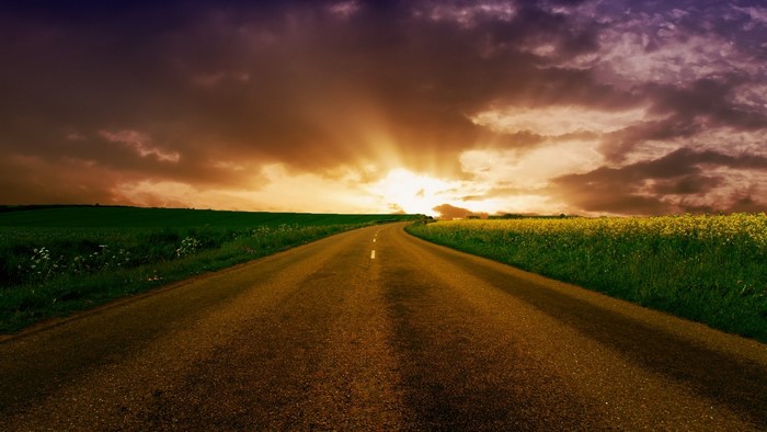 Sunrise over a country road with fields