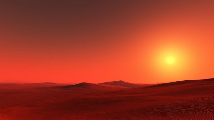 Red desert landscape with a bright sun