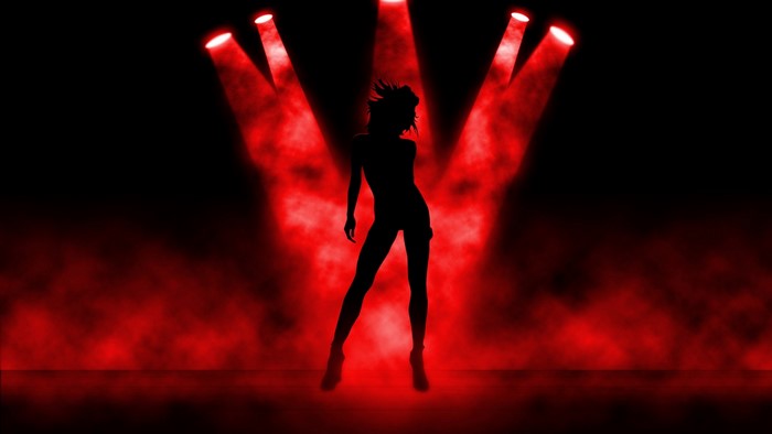 Silhouette of a dancer under red spotlights