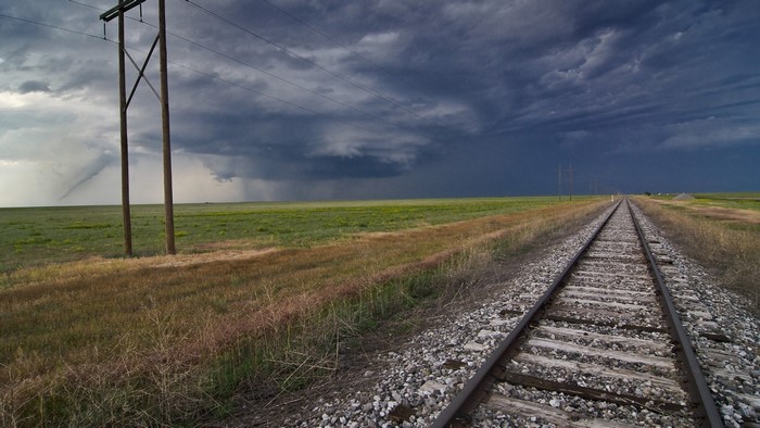 Railroad tracks on a prairie under a stormy sky