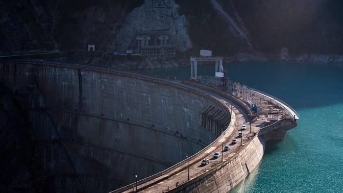 Dam under construction with cars on road