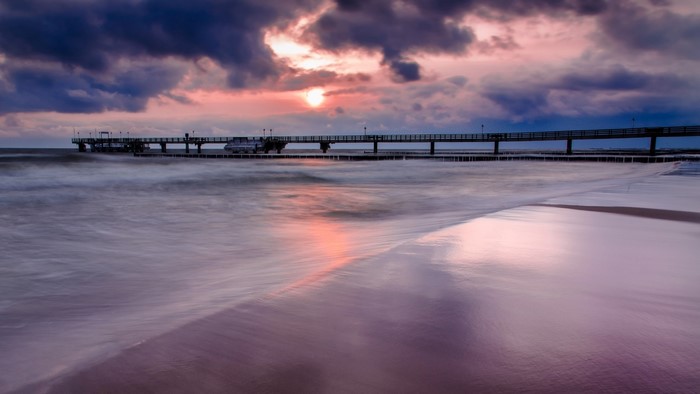 Sea bridge at sunset with pink clouds