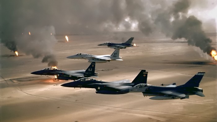 F-15 Eagles and F-16 Fighting Falcon over burning oil wells