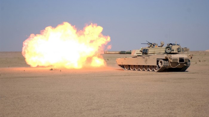 Tank firing a cannon in a desert