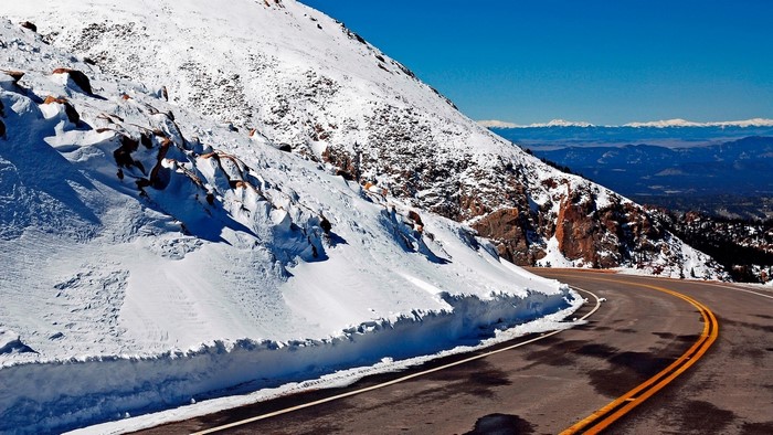 Snowy mountain road with distant mountains