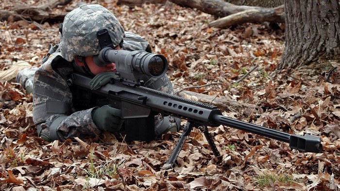Soldier aiming a sniper rifle in a forest