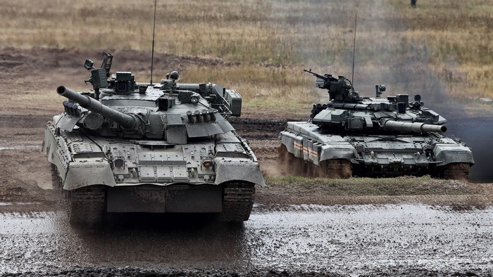 Two Russian T-90 tanks on a muddy field