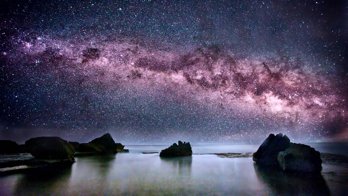 Milky Way Galaxy over ocean rocks