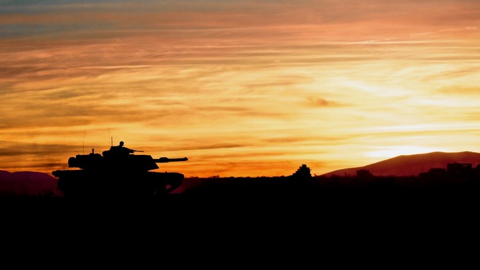 Tank silhouette against a colorful sunset sky