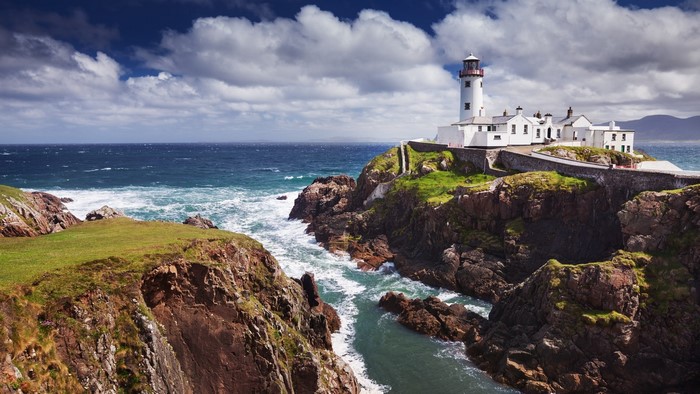 Lighthouse on a rocky coast with ocean waves