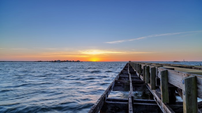 Sunset over the ocean with a wooden pier