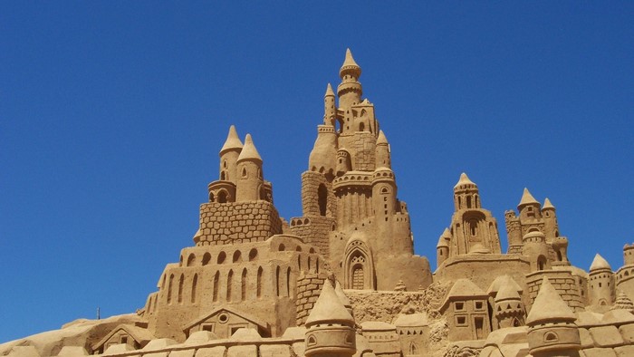 A large sandcastle against a blue sky