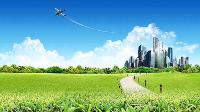 Airplane flying over a futuristic city and green landscape
