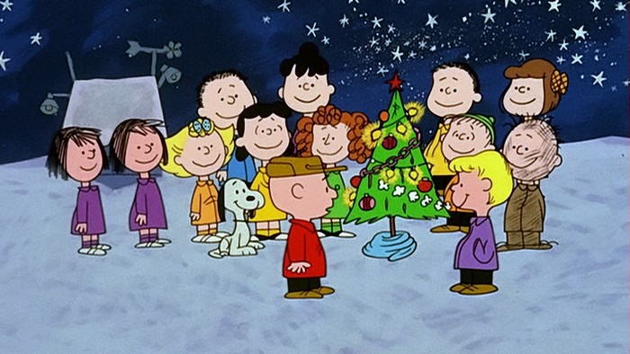 Peanuts Gang gathered around a Christmas tree