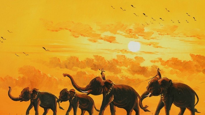 Elephants walking at sunset with birds flying