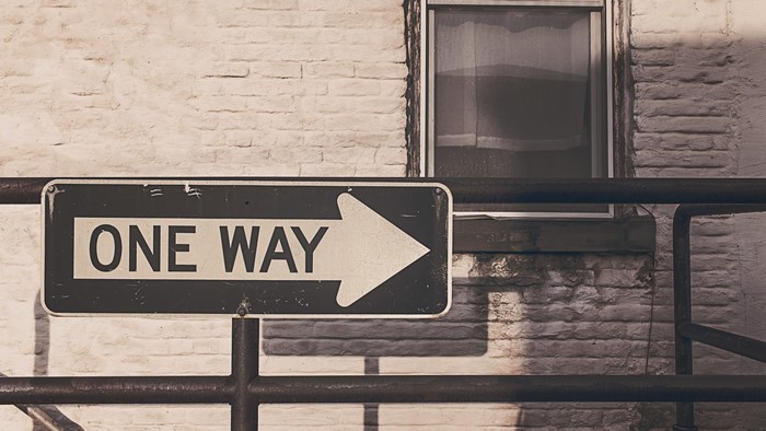One Way Sign on Brick Wall