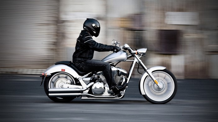 Motorcyclist in Black Riding a Silver Motorcycle