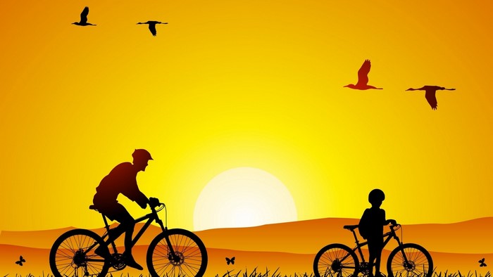 Silhouettes of people cycling at sunrise with birds flying