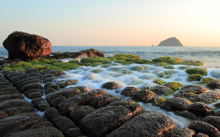 Rocky coastline with moss-covered rocks and ocean waves