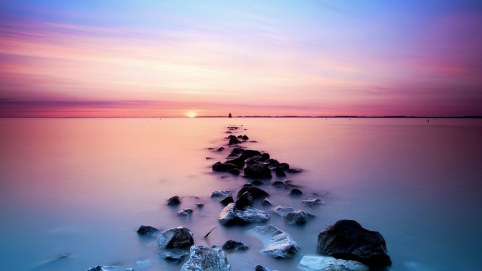 Pastel Sunset Over Water with Rocks