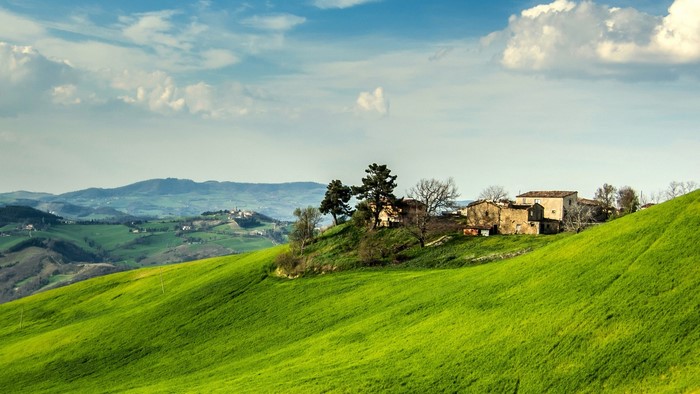Italian countryside with rolling green hills and houses