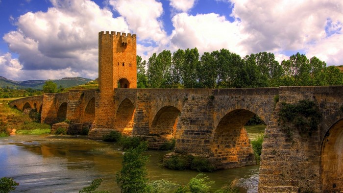 Old stone bridge with a tower over a river