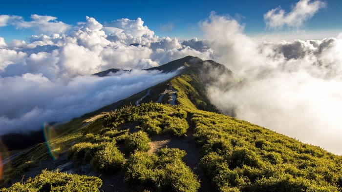 Mountain ridge with clouds and a winding path