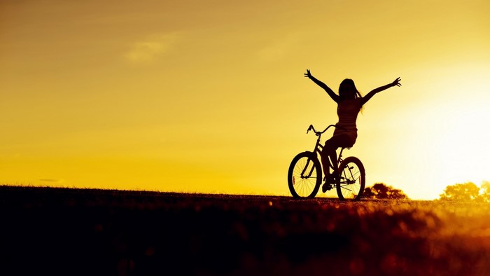Girl on a bicycle at sunset