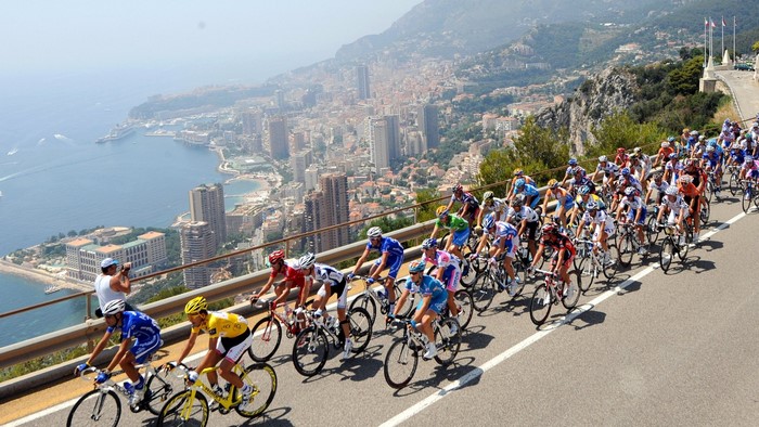 Tour de France cyclists race along a coastal road in Monaco