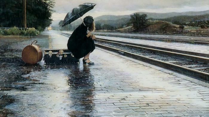 Girl with umbrella and luggage on train platform in rain
