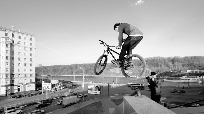 BMX rider jumping with photographer in city