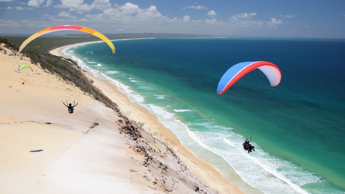 Paragliding over a sandy beach and ocean