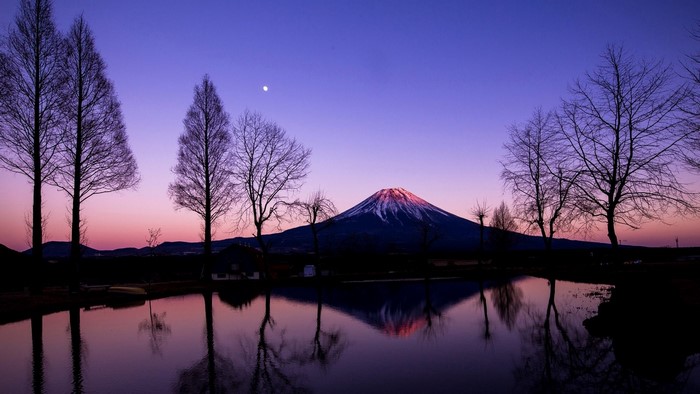 Mount Fuji reflected in a lake at sunset