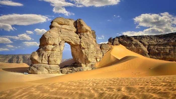 Desert Arch Rock Formation with Sand Dunes