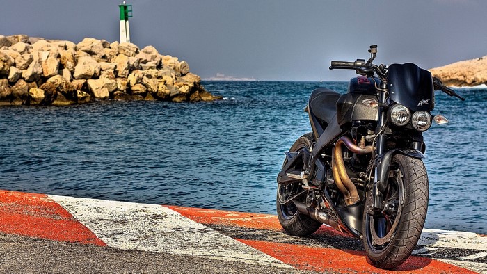 Buell Motorcycle parked by the sea with lighthouse