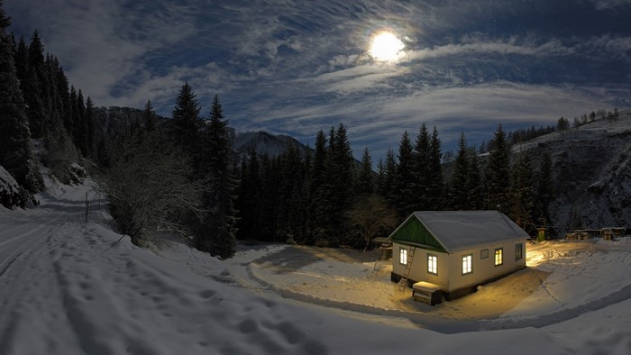 House in snowy mountains under the moon