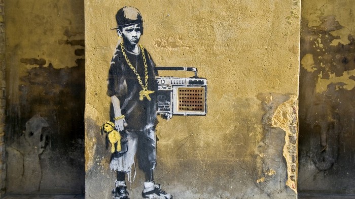 Graffiti of a young rapper with a boombox and teddy bear