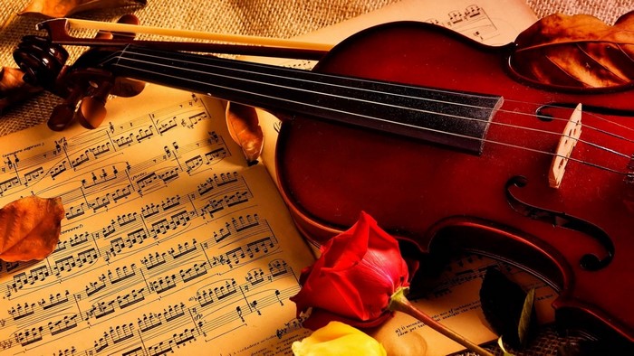 Violin on sheet music with rose and leaves