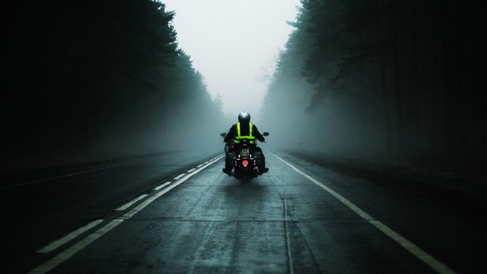 Motorcyclist on a foggy road