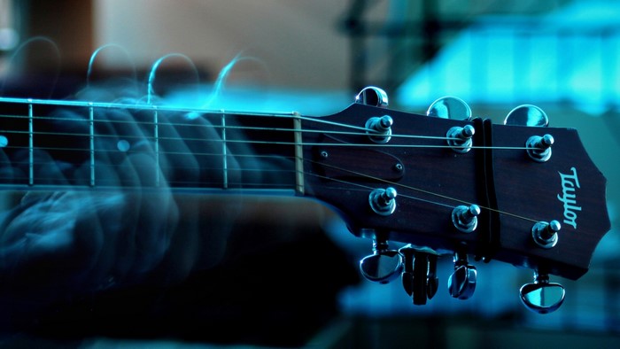 Taylor Acoustic Guitar Headstock with Blurred Hands