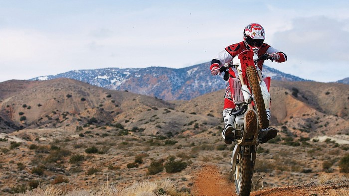 Motocross rider jumping in a desert landscape