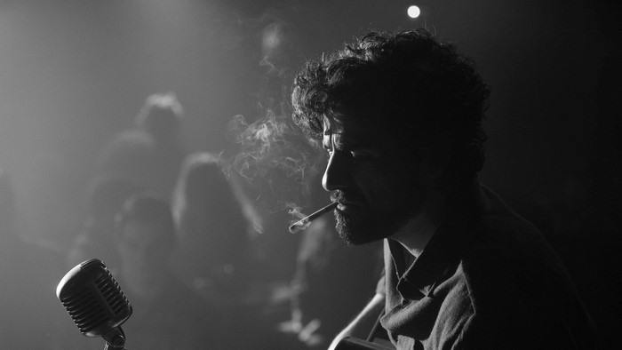 Man smoking in front of a microphone